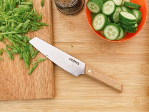 Küchenmesser von Primus auf einem Brett beim Kochen mit Erbsen und Gurken