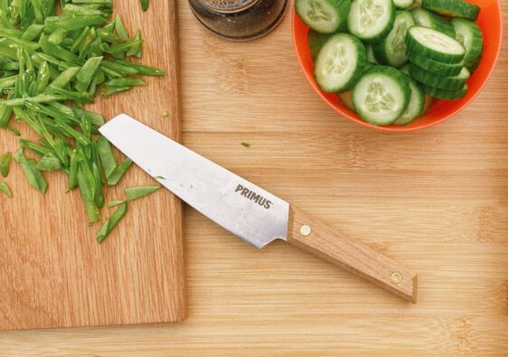 Küchenmesser von Primus auf einem Brett beim Kochen mit Erbsen und Gurken