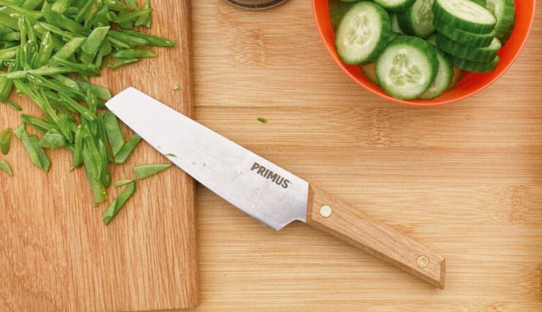 Küchenmesser von Primus auf einem Brett beim Kochen mit Erbsen und Gurken